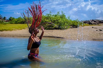 Woman Standing on Body of Water Flipping Her Hair Backwards