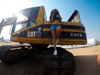 Woman Standing on Cat 320b Excavator