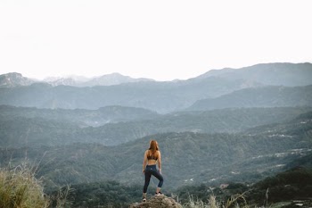 woman standing on cliff during daytime