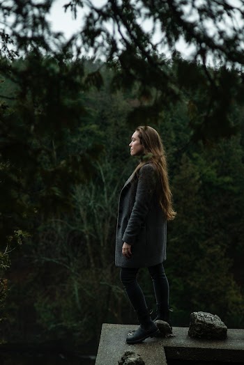 Woman Standing On Concrete Ledge Near Trees
