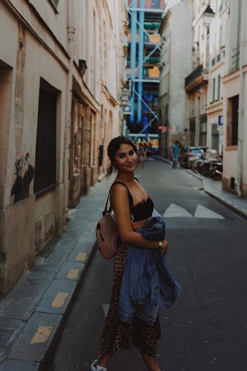 Woman Standing on Concrete Road Between Buildings