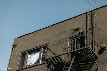 Woman standing on fire escape during the coronavirus lockdown | Free  photo - 2328991
