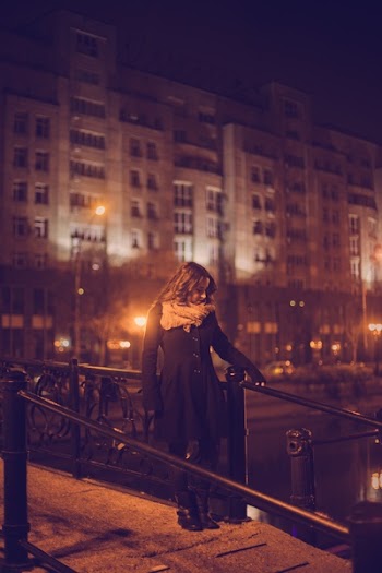 Woman Standing on Footbridge Near River
