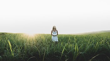 Woman Standing On Grass Field