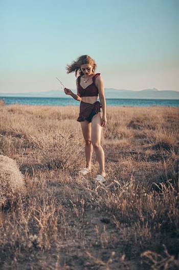 Woman Standing On Grass Near Body Of Water