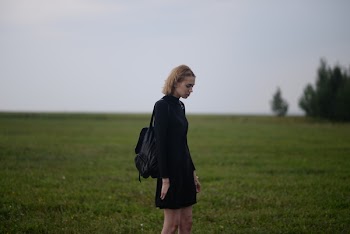Woman Standing on Grass Under Cloudy Day Sky