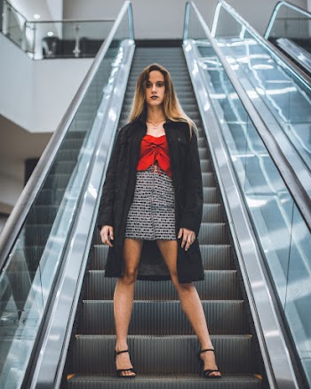 Woman Standing on Gray Escalator