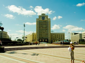 Woman Standing on Ground Overlooking White Concrete Building