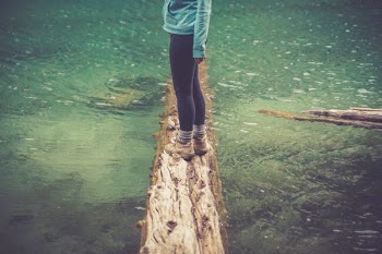 woman standing on log