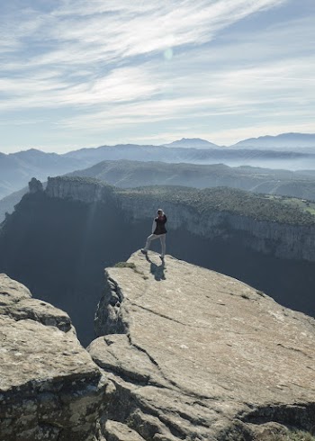 Woman Standing on Mountain Cliff