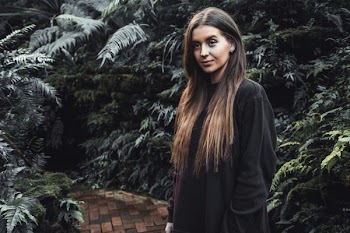 Woman Standing on Pathway Surrounded by Plants