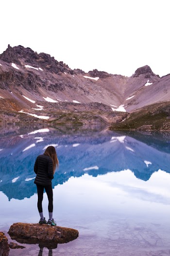 Woman Standing On Rock By The Lake And Mountain 