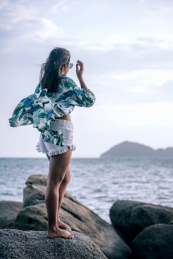 Woman Standing on Rock Near the Ocean