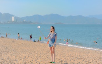 Woman Standing on Seashore Taking Selfie Using Monopod at Daytime