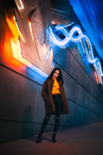 Woman Standing on Sidewalk With Neon Lights