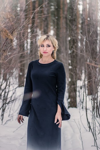 Woman Standing on Snow Covered Land Surrounded With Trees