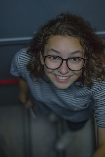 Woman Standing on Stairs Smiling Near Wall