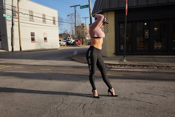 Woman Standing on Street While Raising Her Hand