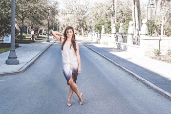 Woman Standing on Street With Cross Leg