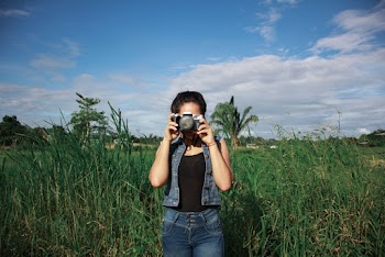 Woman Standing on Tall Grasses Taking Photo