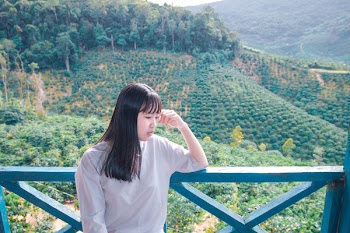 Woman Standing on Terrace Near Grass Field