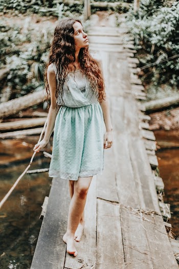 Woman Standing on Wooden Bridge