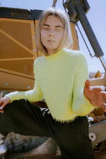woman standing on yellow heavy equipment