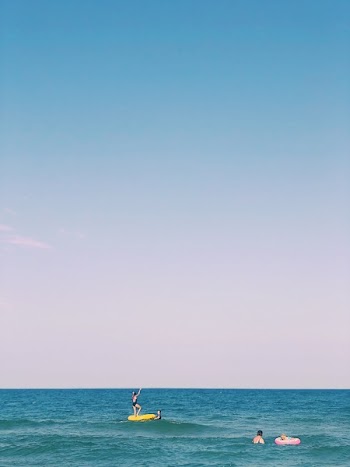 Woman Standing on Yellow Inflatable Ring in Ocean