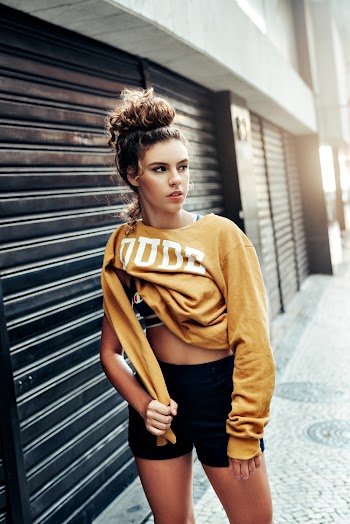Woman Standing Outside a Closed Black Roller Shutter