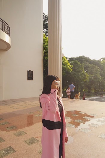Woman Standing Outside Building Taking a Picture