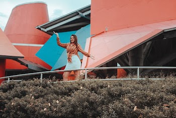 Woman Standing Outside Pink Building