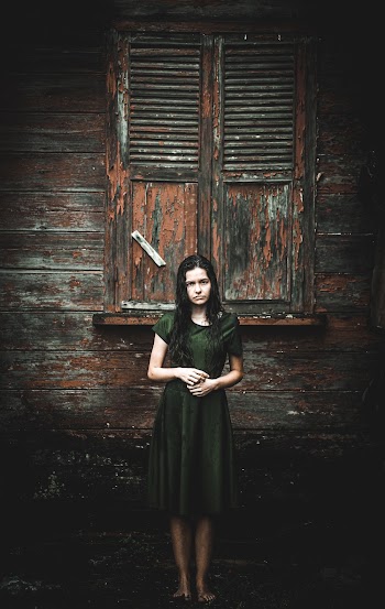 Woman Standing Outside Wooden Building