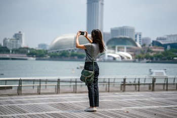 Woman Standing Taking Picture of Scenery