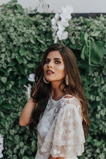 Woman Standing While Holding Her Hair Near Green Plants