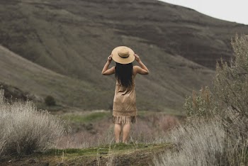 Woman Standing While Holding Her Sun Hat