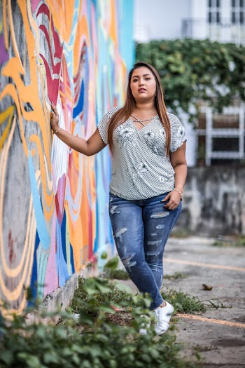 Woman Standing While Holding Multicolored Concrete Wall