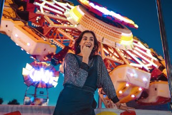 Woman Standing While Laughing Near Yellow Ride Poster