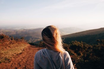 woman standing while looking on mountain range