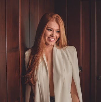 Woman Standing While Smiling Near Wall