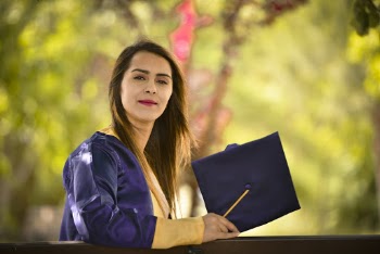 Woman Standing While Wearing Blue Academic Gown
