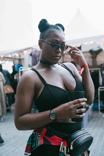 Woman Stands and Holds Her Cup and Sunglasses