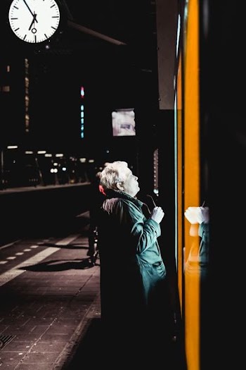 woman staring at the lighted signage at nightime