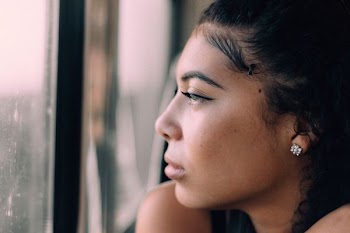 woman staring outside glass window