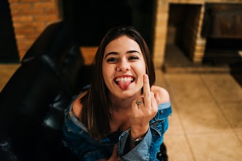 Woman Sticking Out Her Tongue and Raising Her Left Middle Finger