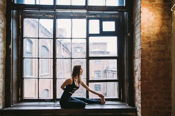 Woman Stretching Beside Window
