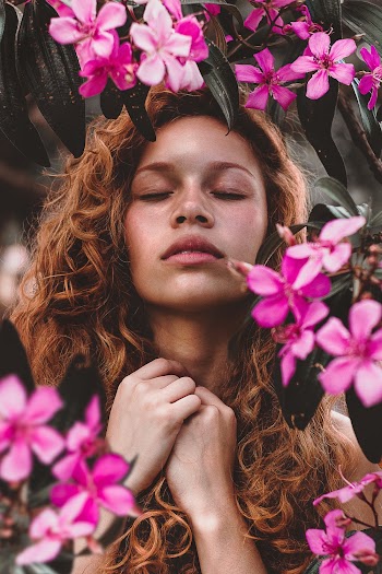 Woman Surrounded by Pink-Petaled Flowers