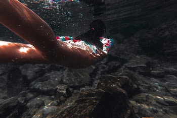 Woman Swimming Under Water Above Rocks