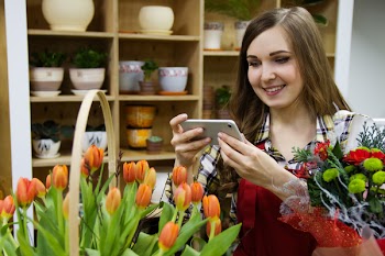 Woman Taking a Photo of Orange Tulips