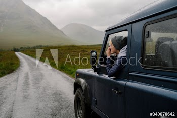 Woman taking a photo out of the car window