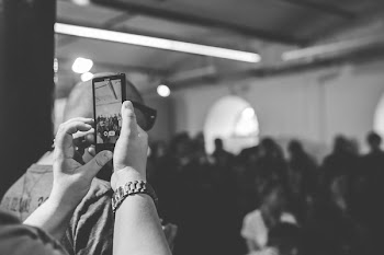 Woman taking a photo with cell phone / bw